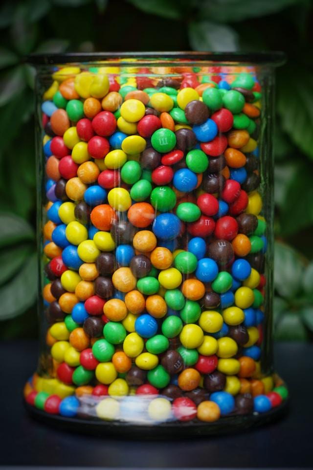 filling glass jar with sweets